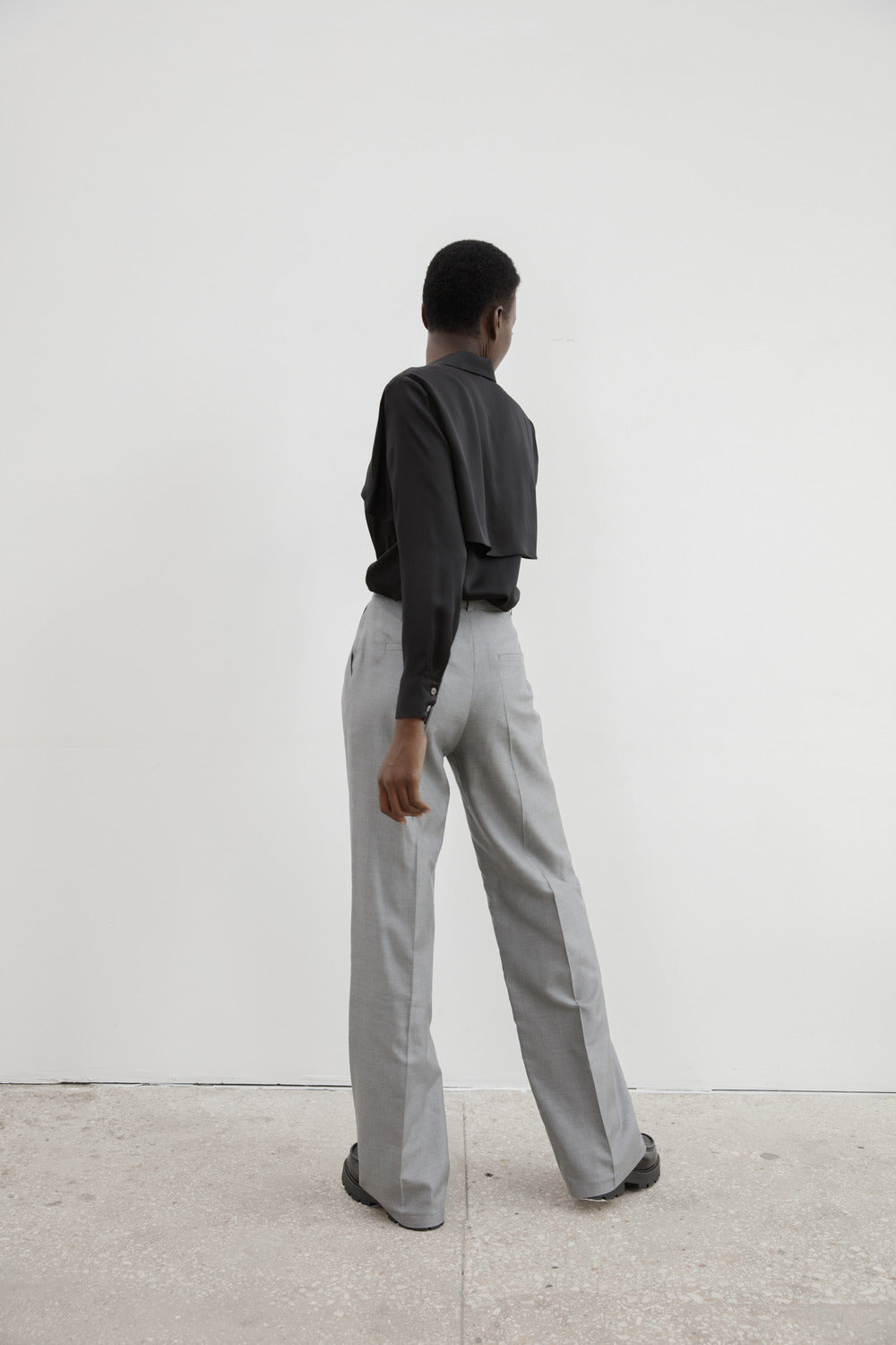 HER CIPHER Back To Business Pant in light grey silk, back view of wide-leg drape with welt pockets and center seam