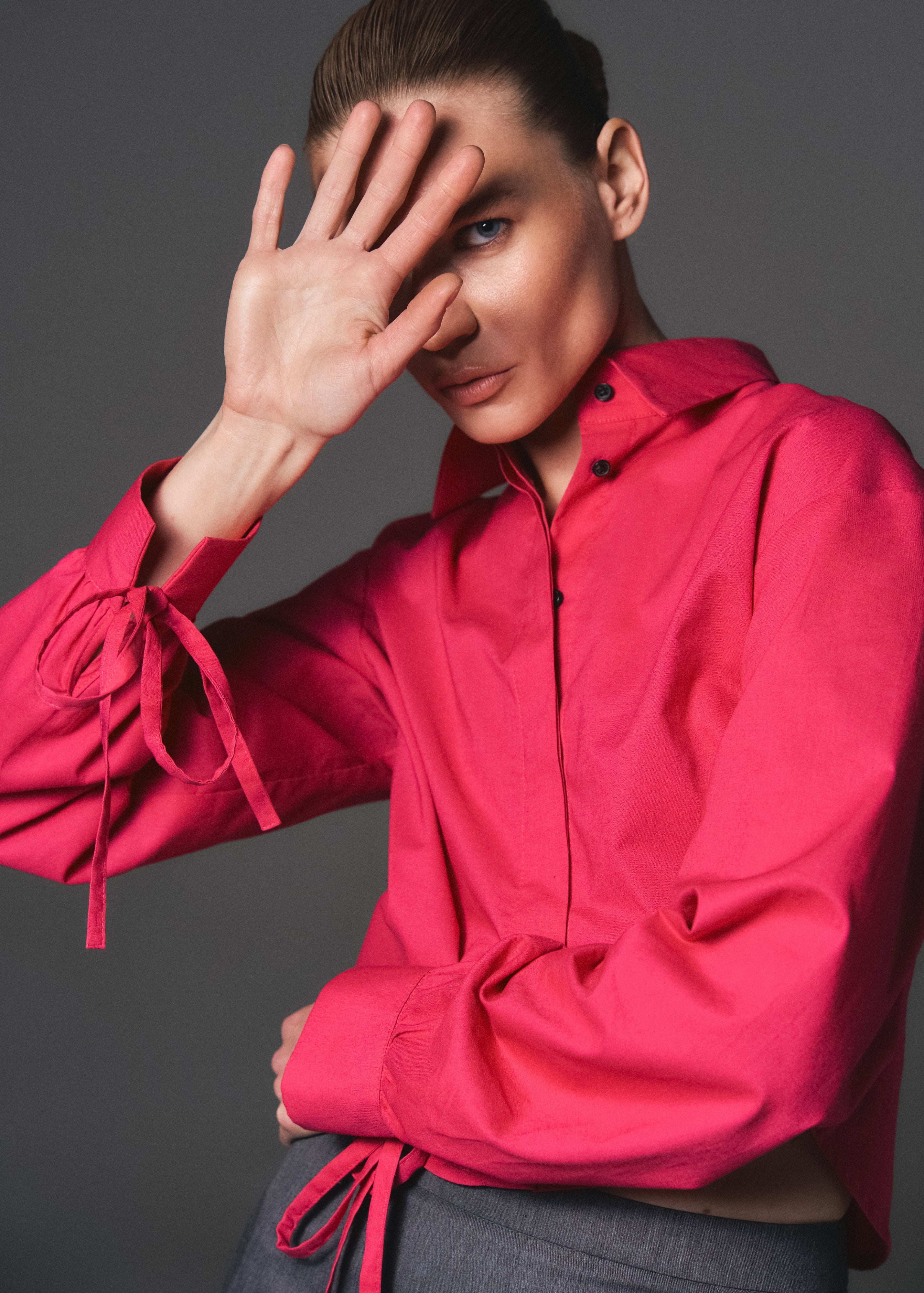 A model posing wearing a sustainable organic 100% cotton shirt in magenta color