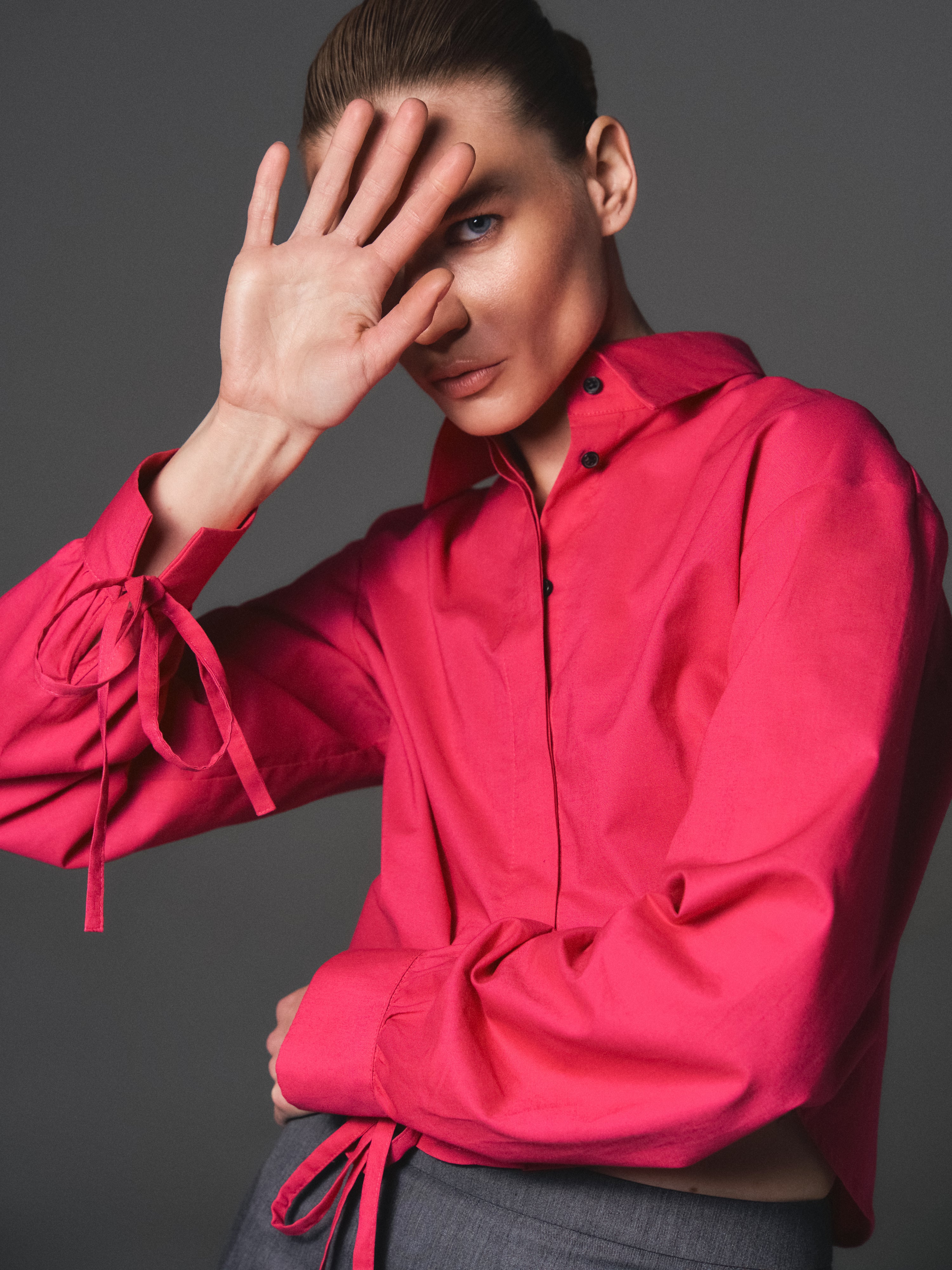 A model posing wearing a sustainable organic 100% cotton shirt in magenta color