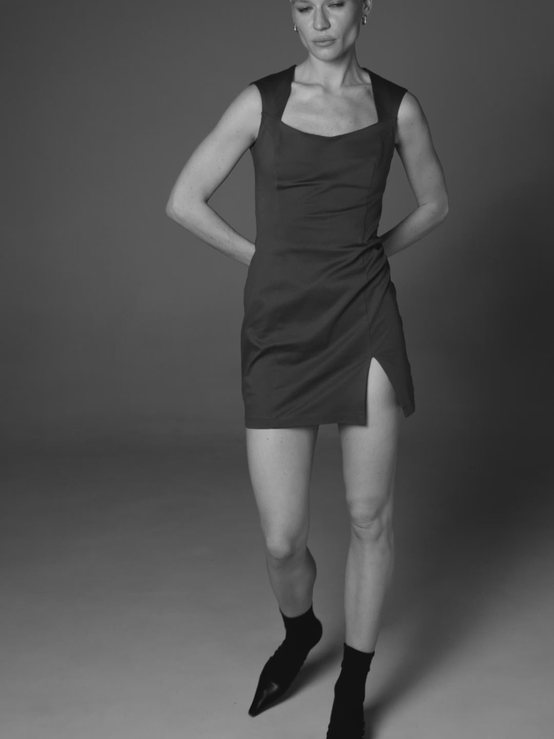 A video of slow motion model posing in a organic cotton grey dress by HER CIPHER with a front slit and square neck